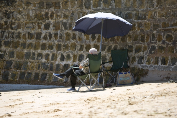 Man relaxing on a beach under a parasol