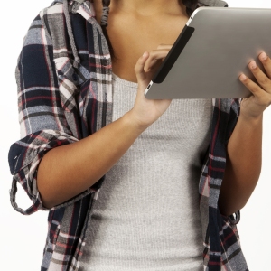 a mixed race teenage girl working on an iPad with white background