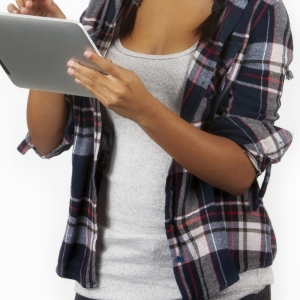 a mixed race teenage girl working on an iPad. White background