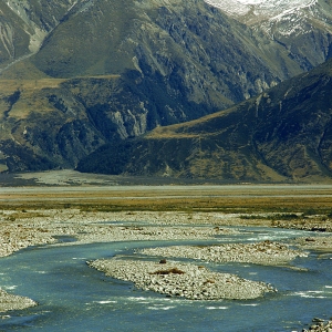 A large, rocky river in the Mountains in a New Zealand landscape