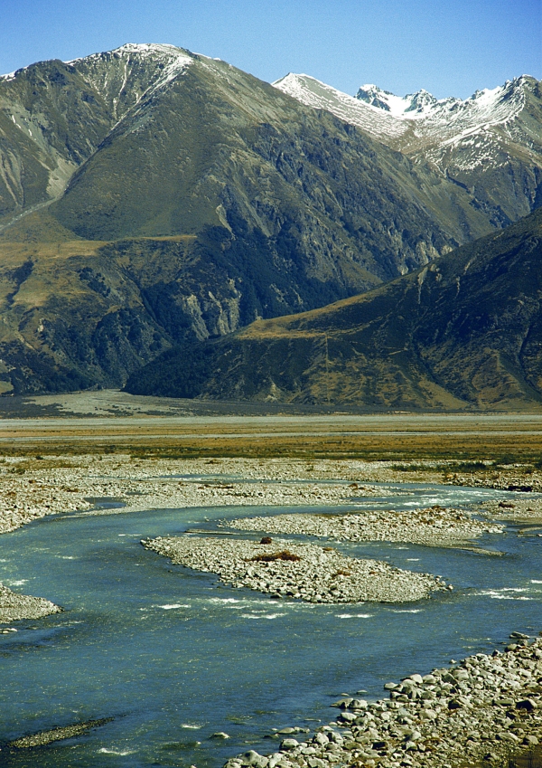 A large, rocky river in the Mountains in a New Zealand landscape