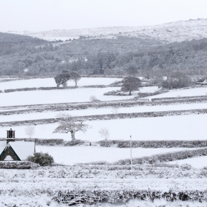 A farm house in a winter landscape with thick snow