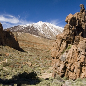 Rocky outcrops in a desert landscape in Tenerife with El Teide in the distance