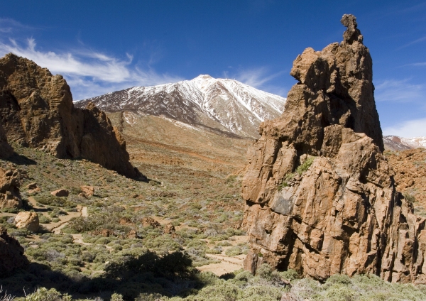 Rocky outcrops in a desert landscape in Tenerife with El Teide in the distance