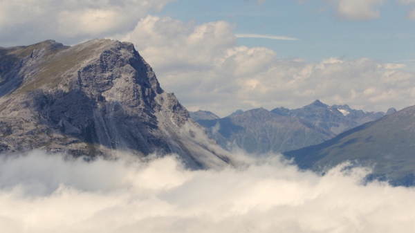 View of beautiful landscape in the Alps - Clouds rolling past the mountains