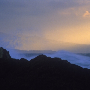 Surf spray against the rocks on an Ibiza coastline at sunset