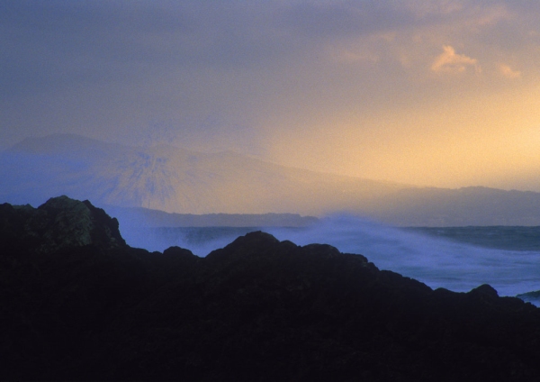 Surf spray against the rocks on an Ibiza coastline at sunset