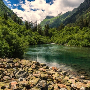 A gin clear lake in the high alps with snow covered peaks in the background