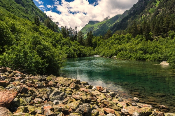 A gin clear lake in the high alps with snow covered peaks in the background