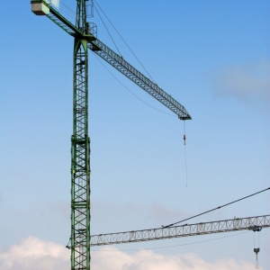 Construction cranes against a blue sky