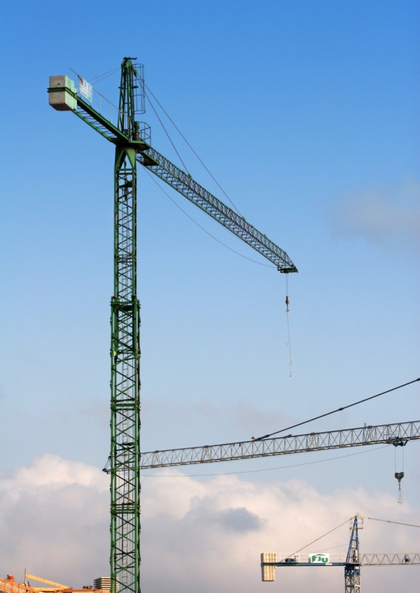 Construction cranes against a blue sky