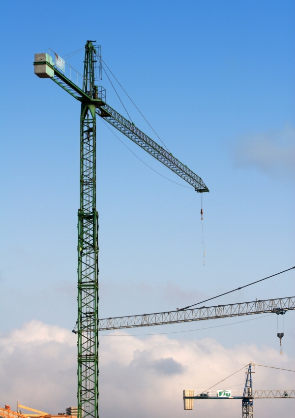 Construction cranes against a blue sky