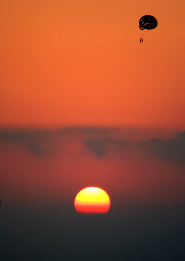 Paragliding at sunset over the mediterranean