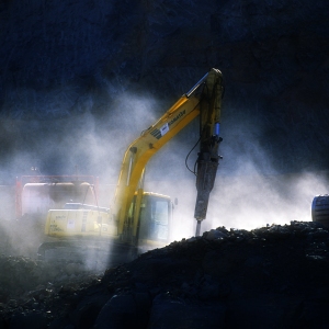 A 360 digger breaking rocks on a road building project