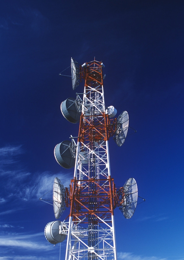 A large telecommunications mast against a blue sky