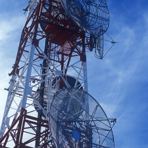 A large telecommunications mast against a blue sky