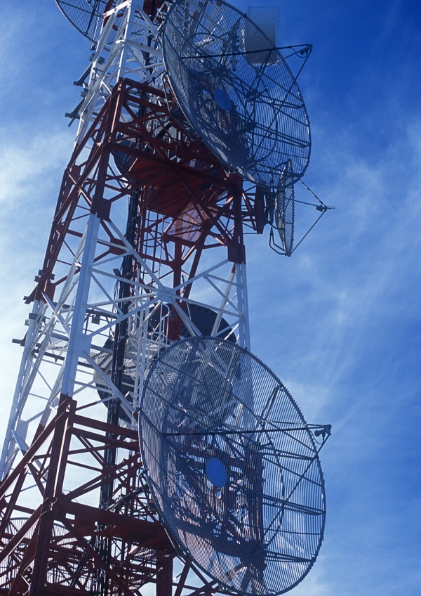 A large telecommunications mast against a blue sky