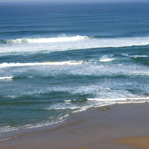 a sandy beach beside the sea under a blue sky