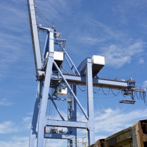 A single dockside crane against a very blue sky