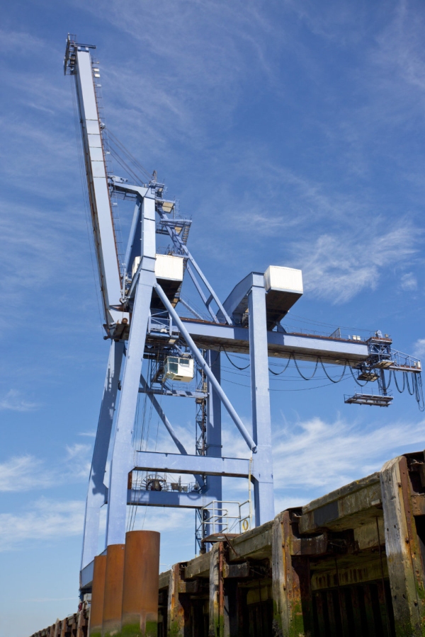 A single dockside crane against a very blue sky