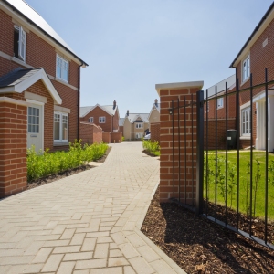 An empty street in a mostly complete new housing development, with houses sold before completion