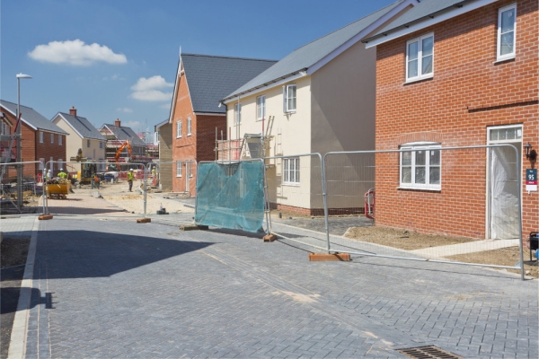 A building site on a large new greenfield housing development with breeze blocks, half built walls, bricks and scaffolding