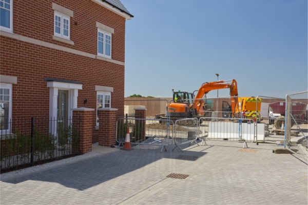 A new house in a greenfield housing development with construction work continuing alongside