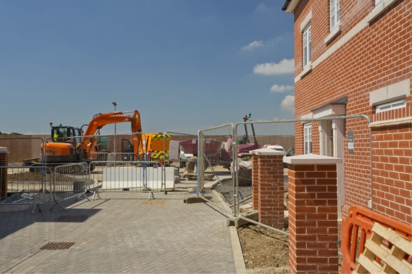 A new house in a greenfield housing development with construction work continuing alongside