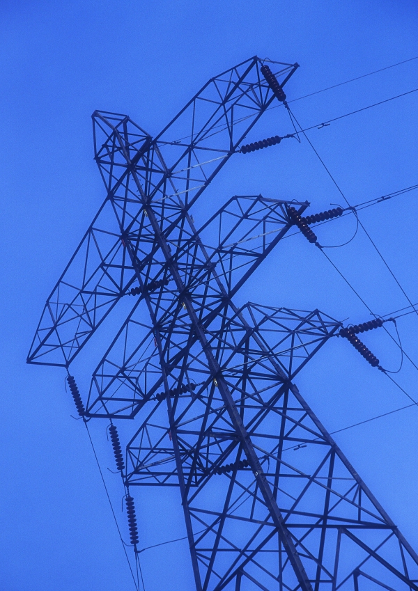 An electricity pylon against a very blue sky