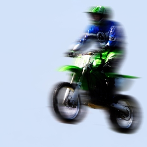 Motorcycle stunt rider in the air with motion blur