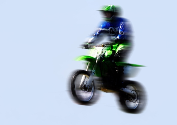 Motorcycle stunt rider in the air with motion blur