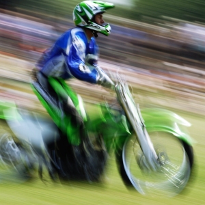 A motorcycle stunt rider at a show, with motion blur