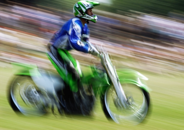 A motorcycle stunt rider at a show, with motion blur