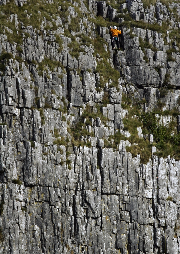 A lone rock climber at a rock face in the pennines