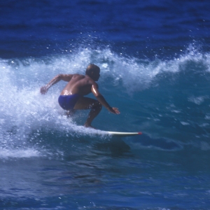 A man surfing a big wave on a sunny summer's day