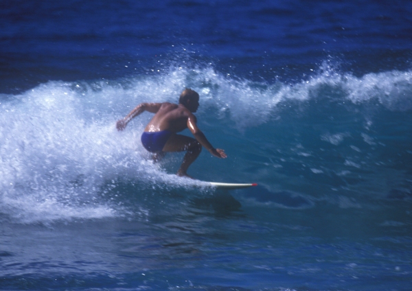 A man surfing a big wave on a sunny summer's day