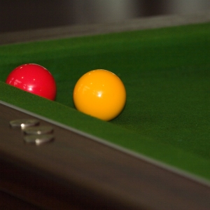 A pool table with yellow and red balls