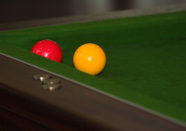 A pool table with yellow and red balls