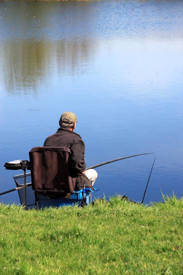 An angler waiting for a bite on a calm lake