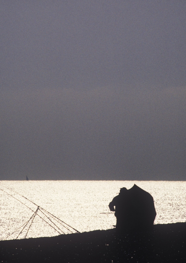 Two anglers sea fishing from a beach