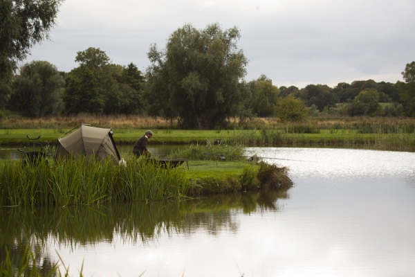 Carp fishing on a placid lake in Suffolk, England