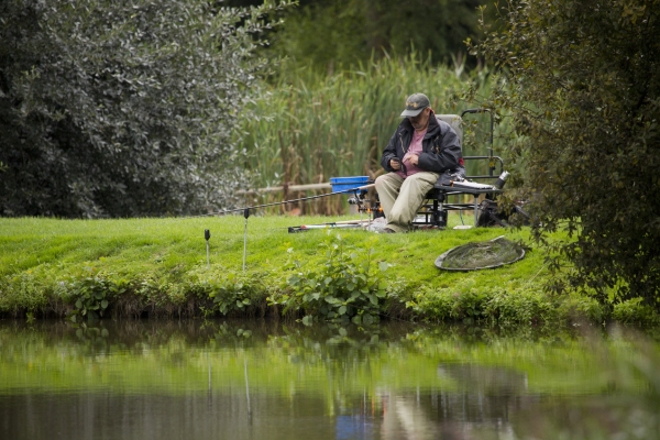 An angler by the waterside waiting for a bite