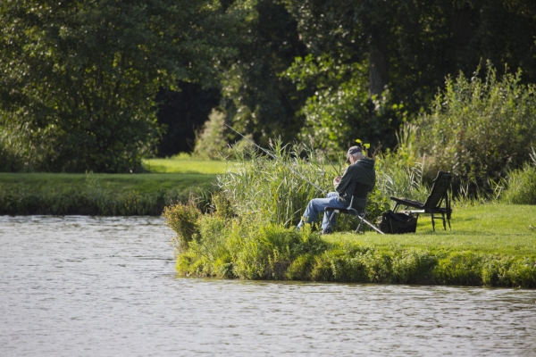 An angler checking his bait while fishing on an English lake in summer