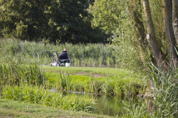 A fisherman watching his float with an electric buggy for his fishing tackle