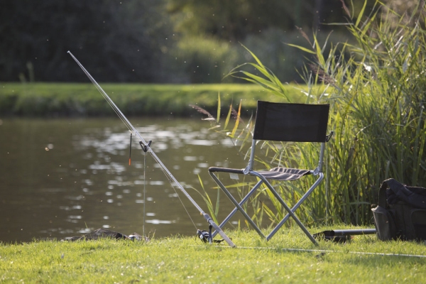 Coarse fishing gear with rod, reel and float set up ready for fishing on a delightful summer evening in suffolk, england