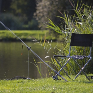 Float fishing tackle set up on a river bank or lakeside on a summer evening in suffolk, england