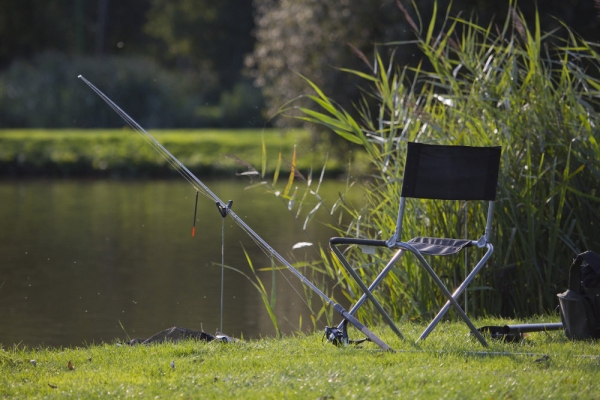 Float fishing tackle set up on a river bank or lakeside on a summer evening in suffolk, england