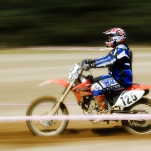 A motocross rider at full speed in a cross country endurance race