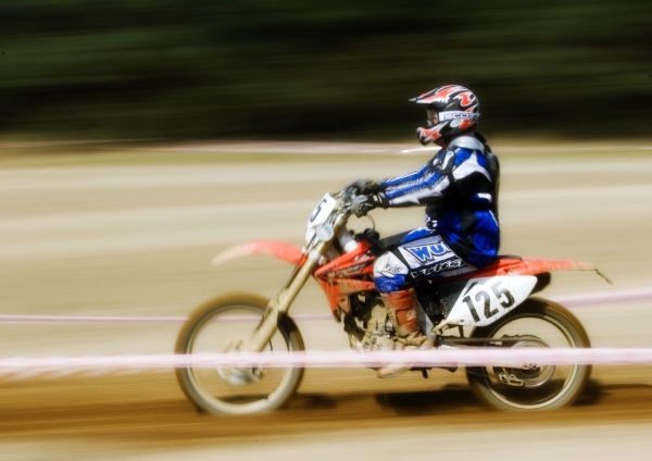 A motocross rider at full speed in a cross country endurance race