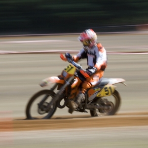 A motocross rider at full speed in a long distance cross country race